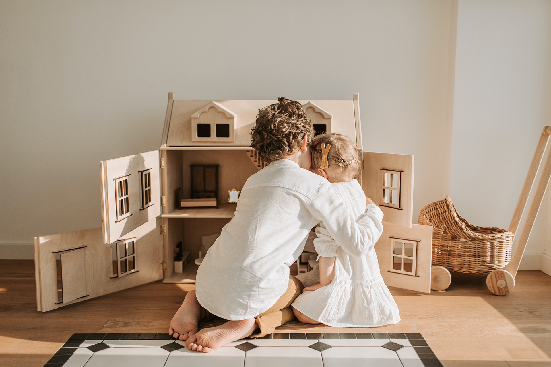 two kids playing with dollhouse